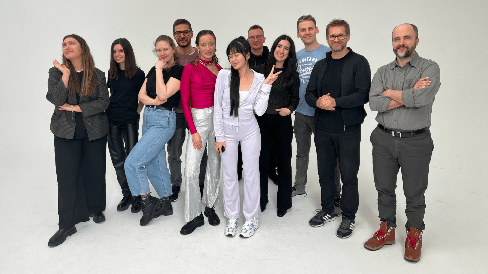 A group of people including both agency staff and models standing together in the photo studio .