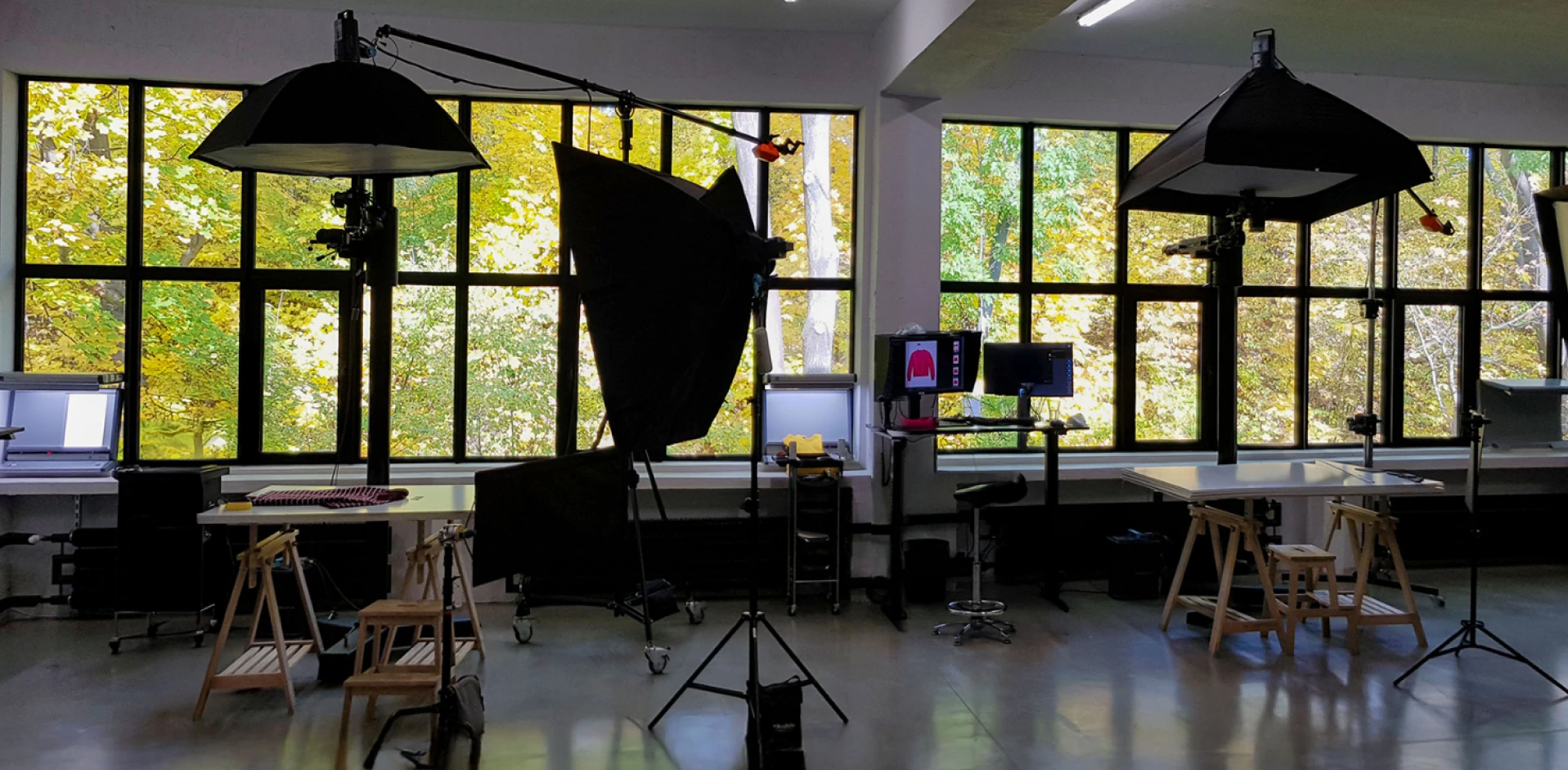 Professional photography studio with lighting equipment, workstations and large windows used for product photography