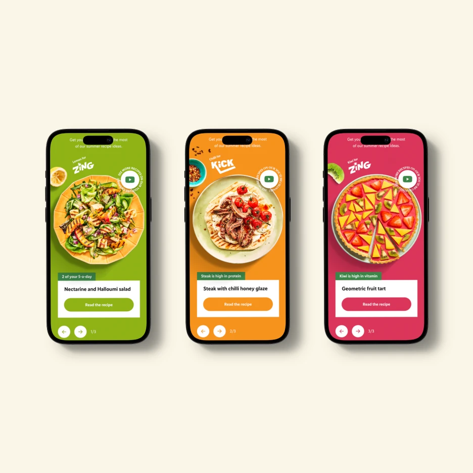 Three smartphones displayed side by side, each showing a colorful recipe card interface featuring plated food photography, bold category colors, and call-to-action buttons to read the recipe.